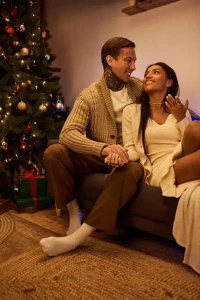 A loving couple enjoys a cozy moment at home, embracing the warmth of Christmas joy. — Stock Photo