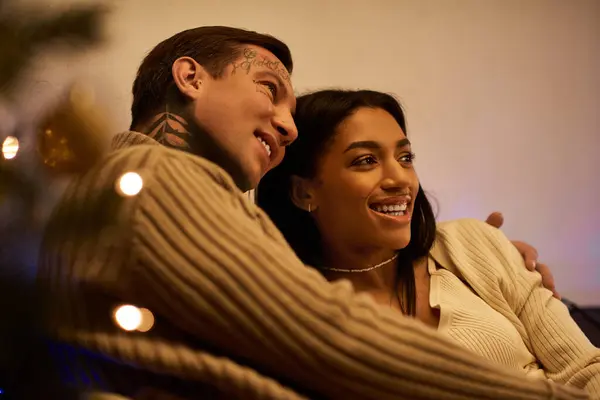 A couple warmly embraces, sharing joyous moments together in their festive home atmosphere. — Stock Photo