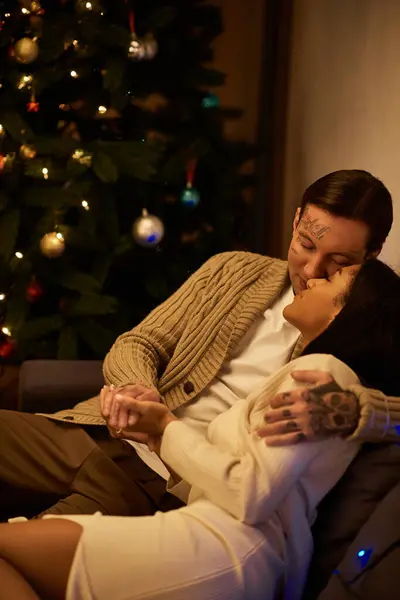 A couple shares a tender moment on the couch, enjoying the warmth of Christmas spirit together. — Stock Photo