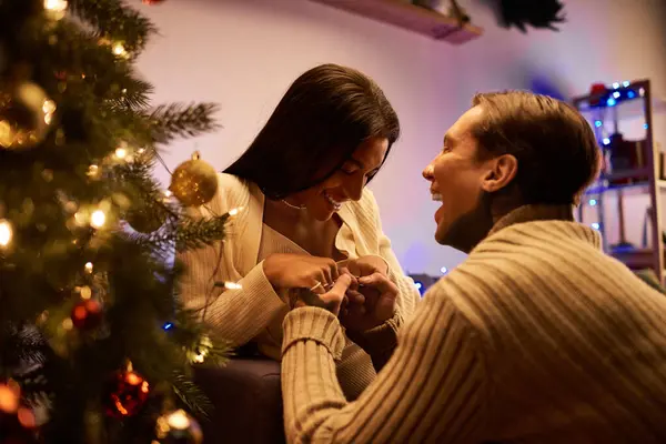 A couple exchanges warm smiles while celebrating the joy of Christmas at home. — Stock Photo