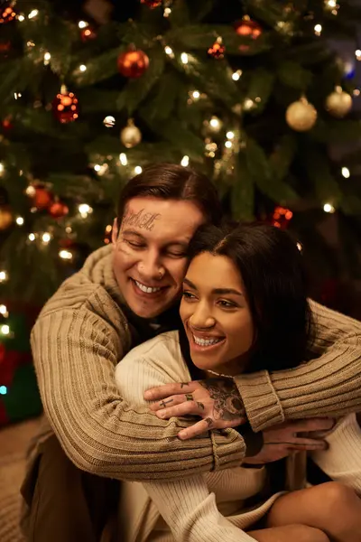 A couple happily cuddles together at home, basking in the warmth of Christmas togetherness. — Stock Photo