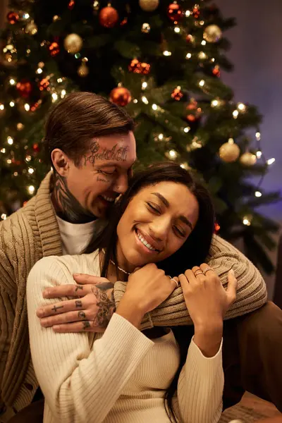 A couple shares laughter and warmth while celebrating Christmas in their beautifully decorated home. — Stock Photo