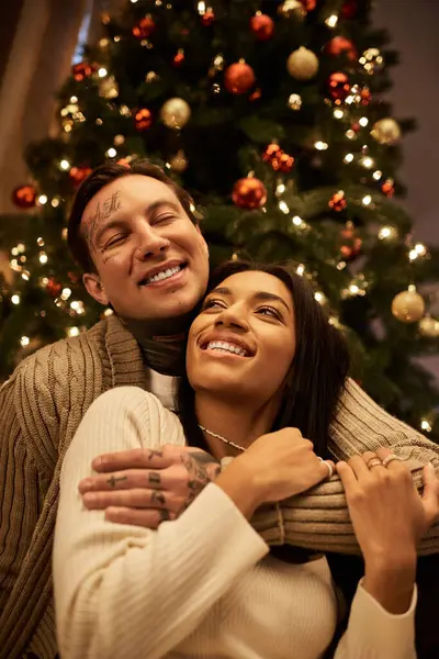 A loving couple enjoys a cozy moment together, surrounded by festive holiday decorations. — Stock Photo