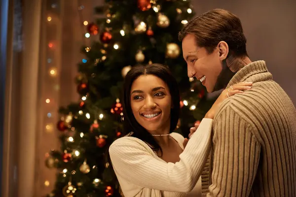 A loving couple shares a joyful moment together at home during the festive Christmas season. — Stock Photo