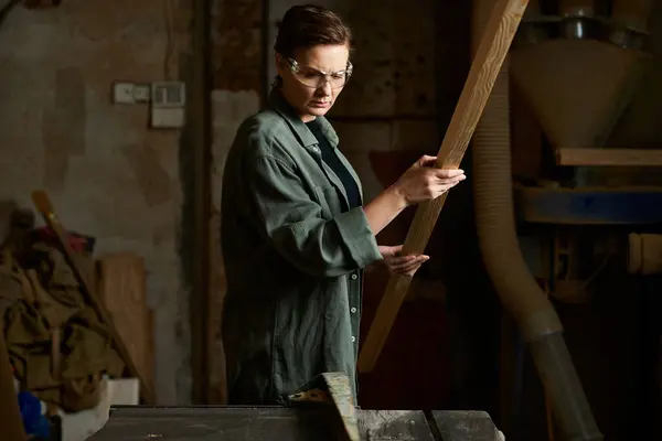 A dedicated carpenter crafts wood with precision in a bustling workshop filled with tools and materials. — Stock Photo