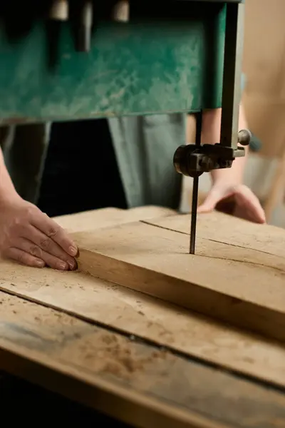 A determined female carpenter carefully works on shaping wood in a well-lit workshop, showcasing her skills. — Stock Photo
