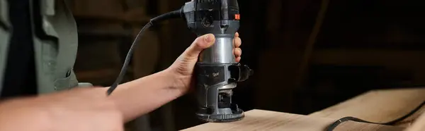 A skilled female carpenter works diligently on a wooden piece with a router, showcasing craftsmanship in the workshop. — Stock Photo