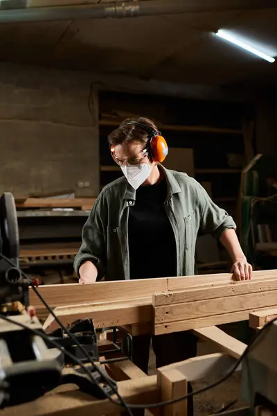 A skilled carpenter meticulously shaping wood in a well-lit workshop filled with tools and materials. — Stock Photo