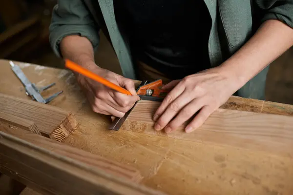 Una experta carpintera femenina se centra en la precisión, la medición y el marcado de la madera cuidadosamente en su espacio de trabajo. - foto de stock
