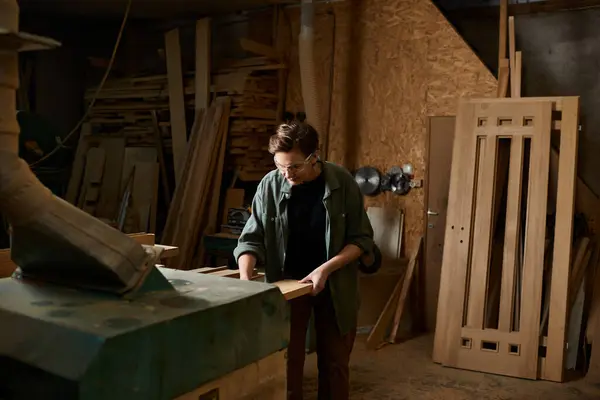 In a well-organized workshop, a talented female carpenter focuses intently on shaping wood pieces with precision. — Stock Photo