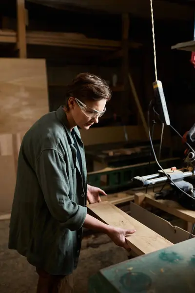 In a vibrant workshop, a talented woman expertly crafts wood, showcasing her craftsmanship and dedication. — Stock Photo