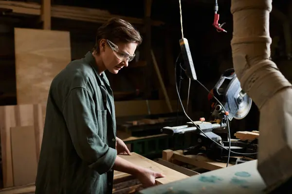 A dedicated carpenter meticulously works on wood, showcasing her craftsmanship in a well-equipped workshop. — Stock Photo