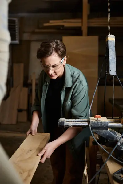 A skilled carpenter focuses intently on crafting wood with precision in an engaging workshop atmosphere. — Stockfoto