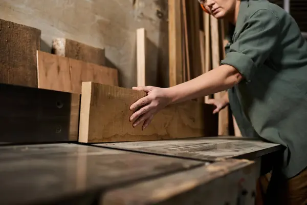 A dedicated carpenter focuses on woodworking, showcasing craftsmanship and precision in her workshop space. — Stock Photo
