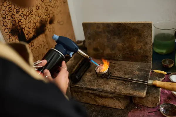 A dedicated artisan uses a torch to melt metal, creating exquisite jewelry designs. — Stock Photo