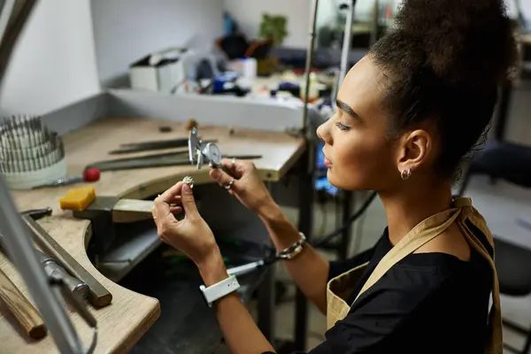 Focused artisan creates stunning jewels while surrounded by tools and materials in her workspace — Stock Photo