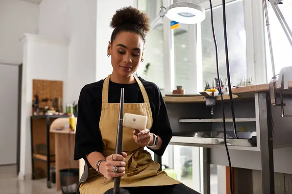 Un artesano experto crea joyas impresionantes mientras se centra e inspira en su espacio de trabajo. - foto de stock