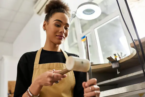 A talented woman focuses on crafting exquisite jewelry with precision and passion in her studio. — Stock Photo