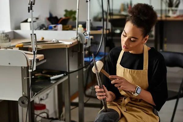 Uma mulher talentosa projeta apaixonadamente uma jóia requintada enquanto está sentada em seu espaço de trabalho criativo. — Fotografia de Stock