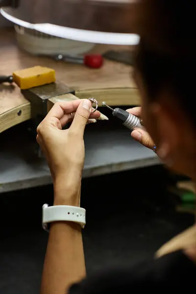 A talented woman focuses intently on creating beautiful jewelry with intricate details. — Stock Photo
