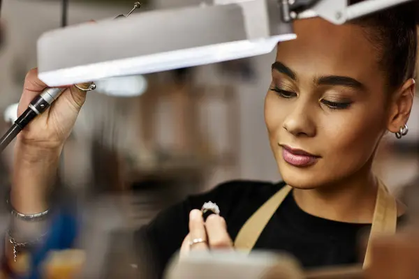 Una donna di talento sta lavorando con attenzione su una gemma preziosa, mettendo in mostra la sua arte e la sua attenzione. — Foto stock