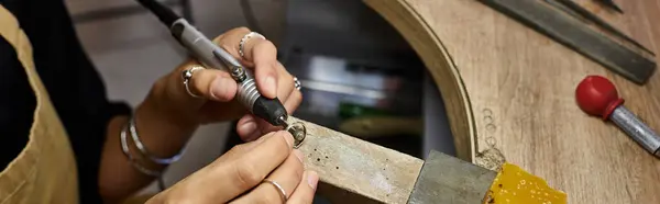 The artisan focuses intently on crafting a delicate piece of jewelry while surrounded by tools. — Stock Photo