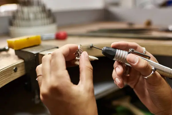 An artisan expertly shapes beautiful jewels while surrounded by a lively workshop atmosphere. — Stock Photo