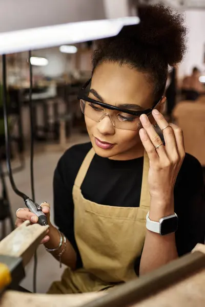 A talented woman with glasses meticulously works on beautiful jewelry, displaying her craftsmanship. — Stock Photo