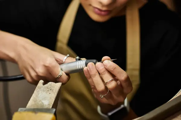 A talented artisan meticulously shapes beautiful jewels with focus and care in their workshop. — Stock Photo