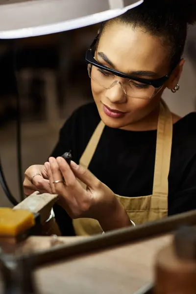 Creating stunning jewelry pieces, the talented artisan focuses on her intricate work with passion. — Stock Photo