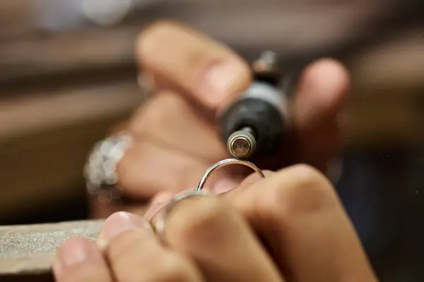 Artisan works meticulously on a silver ring, emphasizing the beauty of intricate jewels. — Foto stock