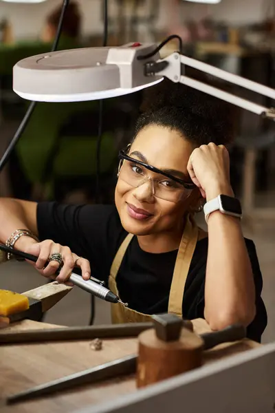 An artisan focuses intently on creating exquisite jewelry, surrounded by tools and materials. — Stock Photo