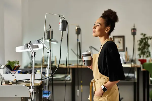 A talented woman in an artistic workspace enjoys a moment of reflection with her drink. — Stock Photo