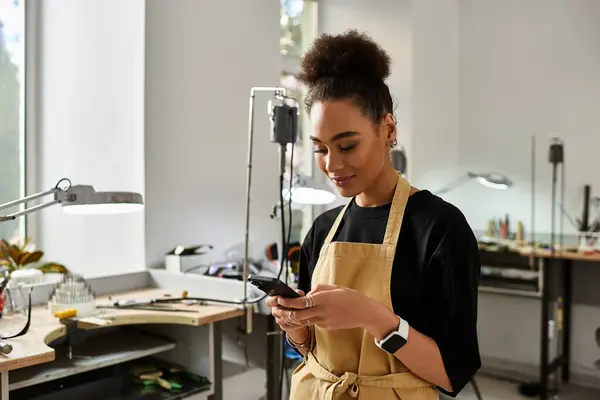 Un artigiano di talento si trova in uno spazio di lavoro vibrante, incentrato sul suo dispositivo mobile e sulla sua creatività. — Foto stock