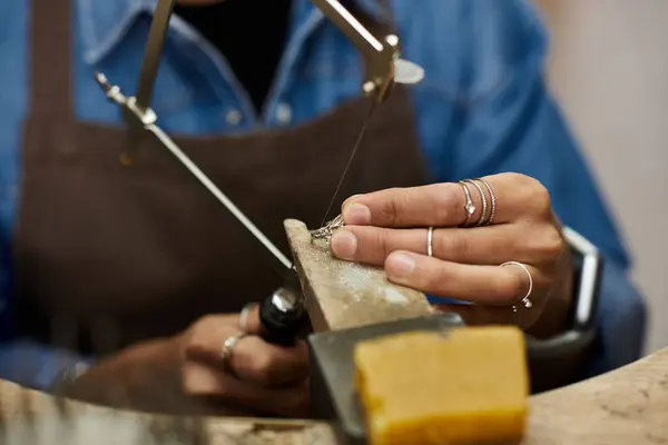 A skilled artisan expertly shapes fine jewelry with meticulous attention in a warm workshop. — Stock Photo