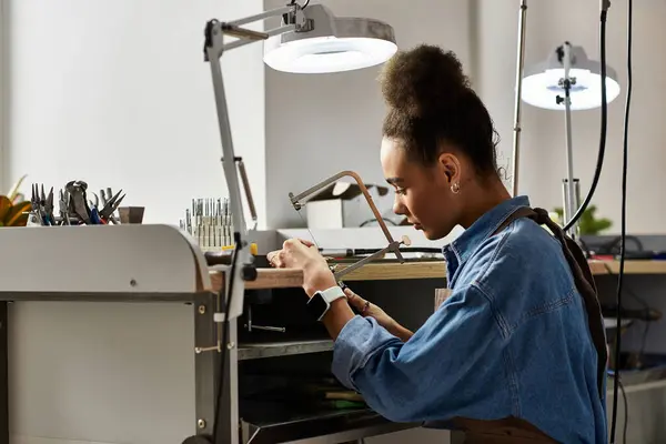 A talented craftsperson focuses on creating beautiful jewelry within a well equipped workspace. — Photo de stock