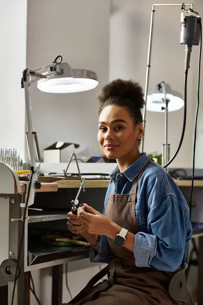 A talented artisan skillfully shapes beautiful jewelry while surrounded by tools and materials. — Stock Photo