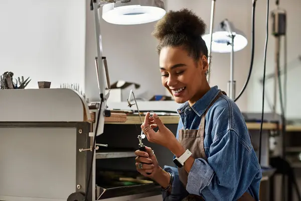 A skilled woman joyfully crafts beautiful jewelry in her workshop. — Stockfoto