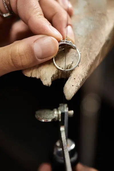 Craftsmanship shines as hands work meticulously on a sparkling ring set in a workshop. — Stock Photo