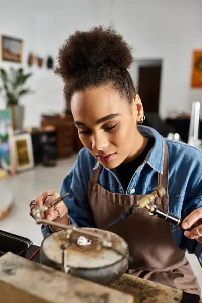 A talented woman meticulously works on a beautiful piece of jewelry in her artistic studio. — Stock Photo