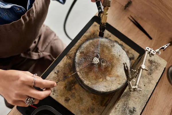 A skilled artisan meticulously designs a beautiful jewel in a creative workshop environment. — Stock Photo