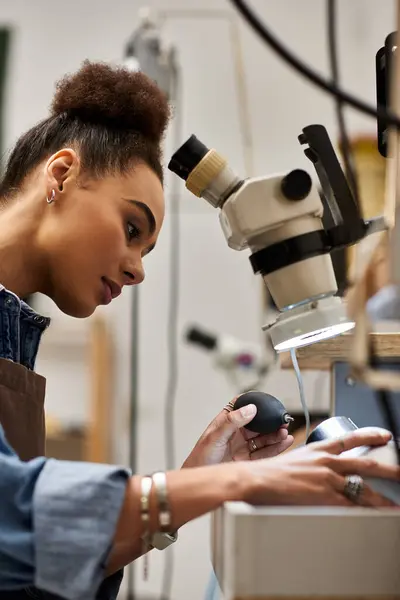 A talented woman examines a unique piece while working diligently in her artistic studio. — Stock Photo