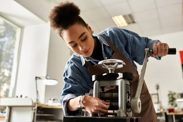 A talented woman engaged with machinery in a bright and inviting craft studio. — Stock Photo