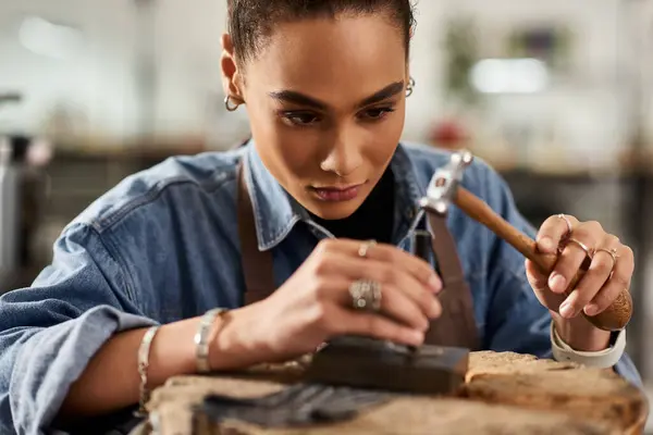 A skilled artisan meticulously designs fine jewelry while surrounded by tools and gems. — Stock Photo