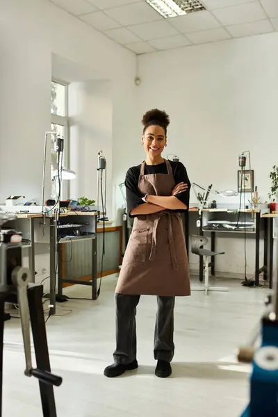 A skilled woman confidently showcases her craftsmanship in her jewelry workshop. — Stock Photo