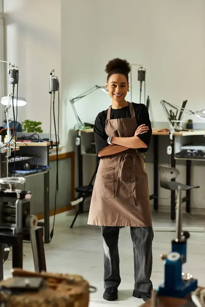 In a bright workshop, a confident artisan smiles while showcasing her craft and tools. — Stock Photo