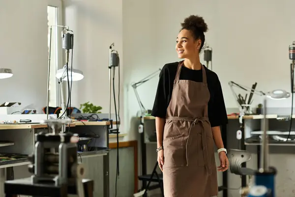 A talented woman stands confidently in a well equipped workshop, surrounded by tools. — Stock Photo