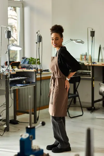 The artisan stands confidently in a sunlit workshop, showcasing her intricate jewelry skills. — Stock Photo