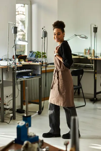 A talented woman works joyfully in her well equipped jewelry studio surrounded by tools. — Stock Photo