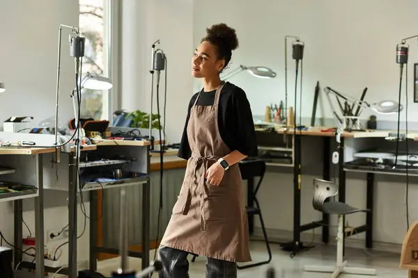 A talented woman in an apron crafts stunning jewelry, surrounded by a bright, inspiring workspace. — Stock Photo